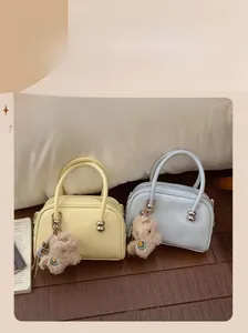 Détail de sacs Boston jaunes et bleus avec billes argentées et breloques mouton
