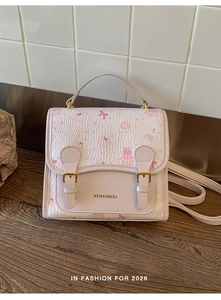 Close-up of pink kitten print and gold buckles on a sweet vintage style handbag