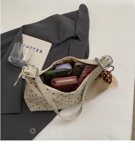 Vista interna della borsa beige a pois che mostra la grande capacità per telefono e portafoglio