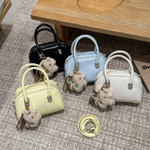 Gros plan de quatre mini sacs Boston en cuir brillant avec charms alpaga mignons