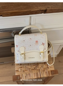 Detail of cute cartoon patterned handbag with gold buckles on a stylish crossbody bag