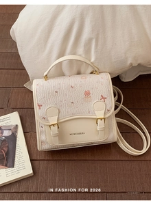Detail of cream PU leather backpack featuring cute cat prints and gold metal hardware