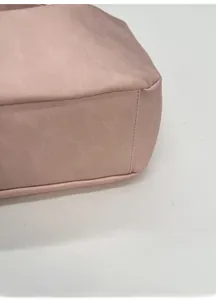 Detailed macro view of reinforced bottom and precision stitching on pink leather tote bag