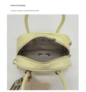 Vue intérieure du sac bandoulière jaune pâle montrant le compartiment et la poche zippée