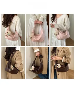 Detail view of pink and brown hobo bags with plush bear charms and adjustable straps
