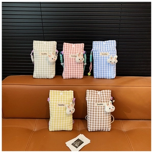 Detail van vijf geruite crossbody telefoontasjes met konijnenhangers en geweven riemen