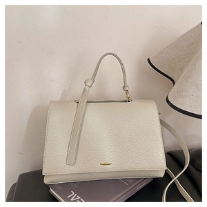 Détail du sac beige en cuir grainé avec un fermoir élégant en métal doré chic