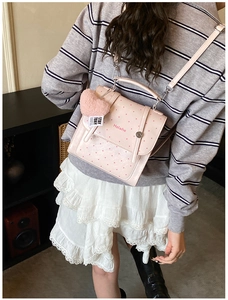 Detail of pink polka dot mini backpack with heart charm and silver hardware