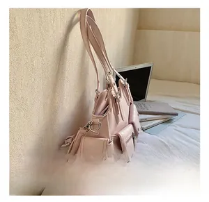 Pink multi-pocket PU tote bag detail with silver zippers and metal hardware on white bedding