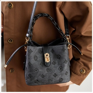 Detailed view of dark grey bucket bag with floral jacquard pattern and gold twist lock