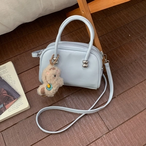 Sac à main en cuir verni bleu clair avec charm mouton et détails de boules en métal