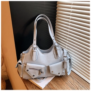 Close-up of light blue motorcycle tote bag with metallic rivets on a wooden windowsill