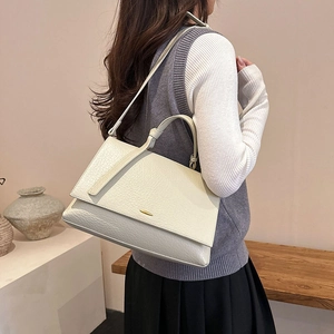 Gros plan du sac en cuir blanc crème avec texture grainée et détails en métal doré