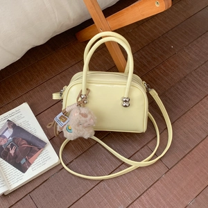 Vue détaillée du sac Boston jaune en similicuir avec un joli pendentif mouton en peluche