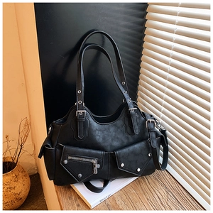 Close-up of black retro leather bag featuring silver rivets and vintage buckle accents