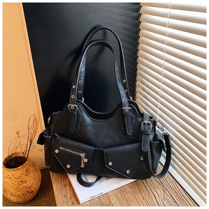 Detail of a vintage biker-style black tote bag featuring multi-pockets and silver hardware