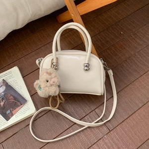 Détail du sac à main blanc cassé en cuir PU avec boule argentée et pendentif peluche