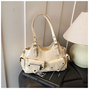Close-up of off-white vintage biker bag with multiple pockets on design books