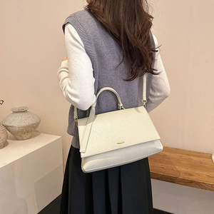 Détail du sac en cuir grainé blanc crème avec boucle dorée et poignée supérieure fixe