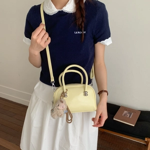 Détail du sac bandoulière jaune clair avec un ourson en peluche et sangle réglable