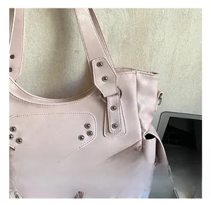 Détails d'un sac cabas rose clair avec rivets argentés et finition en similicuir grainé