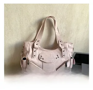 Gros plan du sac fourre-tout rose clair avec rivets argentés et détails de fermeture