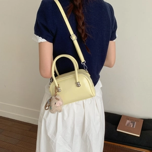 Sac à main Boston en cuir jaune pâle avec breloque en peluche porté en bandoulière