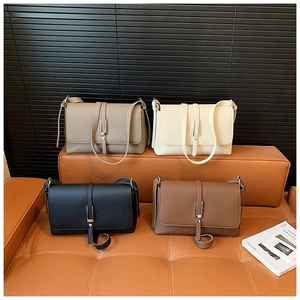 Multiple colors of vintage square crossbody bags in textured leather on a leather bench