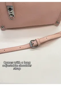 Detail of light pink leather bag with silver buckle and adjustable shoulder strap