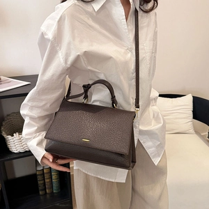 Détails d'un sac cabas en cuir marron grainé avec boucle dorée et bandoulière