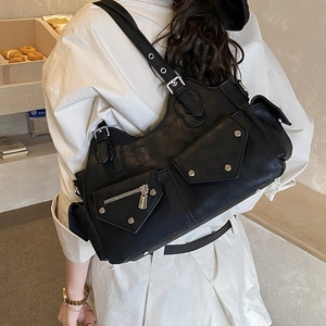 Detail of black faux leather motorcycle tote bag with silver studs and multiple pockets