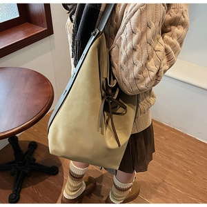 Détail du sac cabas en daim kaki avec nœud en cuir marron et large bandoulière