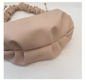 Nahaufnahme der beigen Leder-Wolktasche mit Scrunchie-Griff und Lychee-Struktur