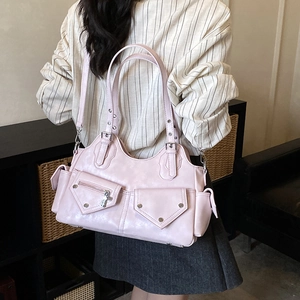 Detail of pink multi-pocket shoulder bag with silver studs and zipper accents
