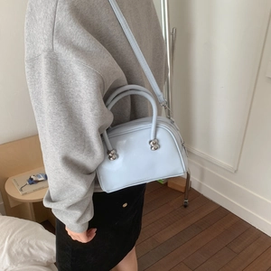 Détail du sac Boston bleu clair avec ferrures sphériques argentées et deux poignées