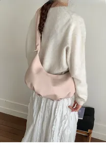 Rosafarbene Hobo-Umhängetasche in Lederoptik kombiniert mit einem minimalistischen Outfit