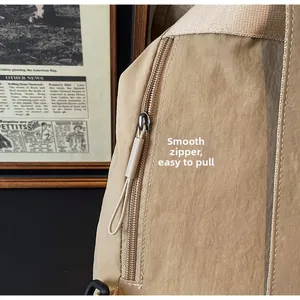 Close-up of smooth metal zipper and durable nylon fabric on large khaki backpack