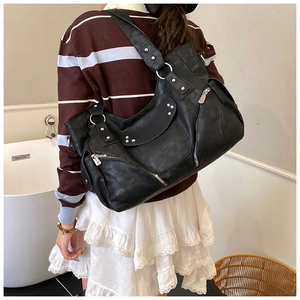 Gros plan sur le sac fourre-tout noir à rivets avec détails argentés et fermetures éclair