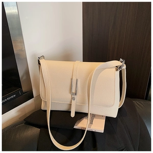Detail of cream-colored lychee pattern leather shoulder bag with silver buckle