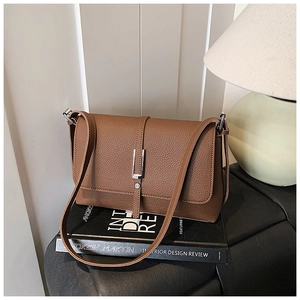 Detail of vintage brown square crossbody bag on a book with soft interior lighting
