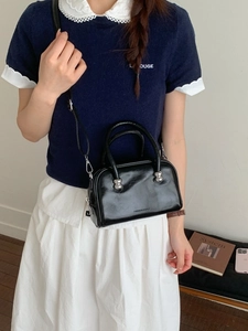 Petit sac Boston en cuir verni noir brillant avec bandoulière et détails argentés