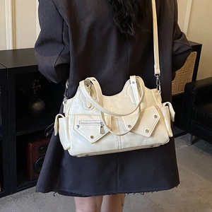 Detail shot of off-white motorcycle shoulder bag with multiple zipper pockets on a model