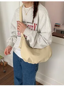 Detailansicht einer weichen beigen Hobo-Schultertasche mit natürlichen Falten