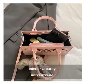 Capacité interne du sac à bandoulière en cuir rose montrant le rangement du maquillage