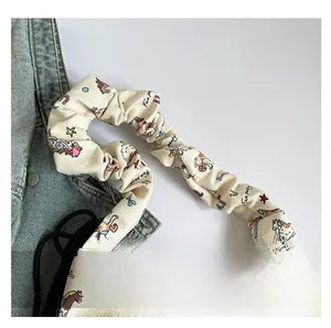 Detail of the gathered scrunchie shoulder strap and colorful horse print on a canvas tote