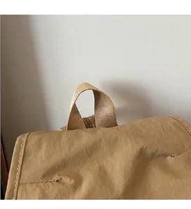 Close-up of the reinforced khaki nylon top handle with durable stitching detail