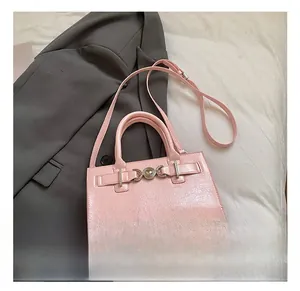 Détail du sac à main rose verni avec boucle argentée posé sur une veste de blazer grise
