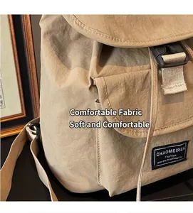 Close-up of khaki backpack with textured fabric buckle closure and brand label