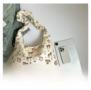 Detail of cartoon pony canvas tote bag with ruched strap shown next to an iPad for size