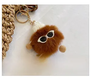 Detail of brown plush charm with knit hat and sunglasses attached to woven straw bag